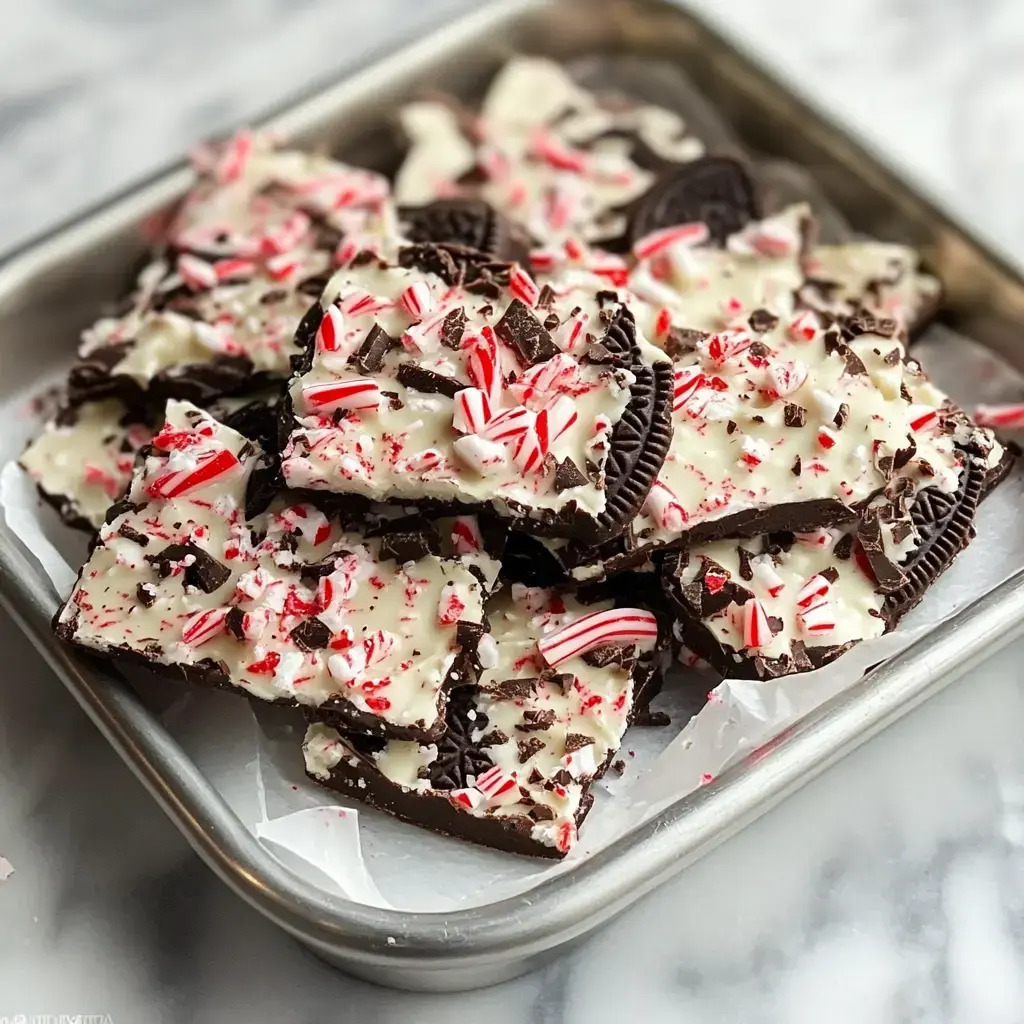 Crushed mint candy and Oreos on chocolate pieces in a tray.