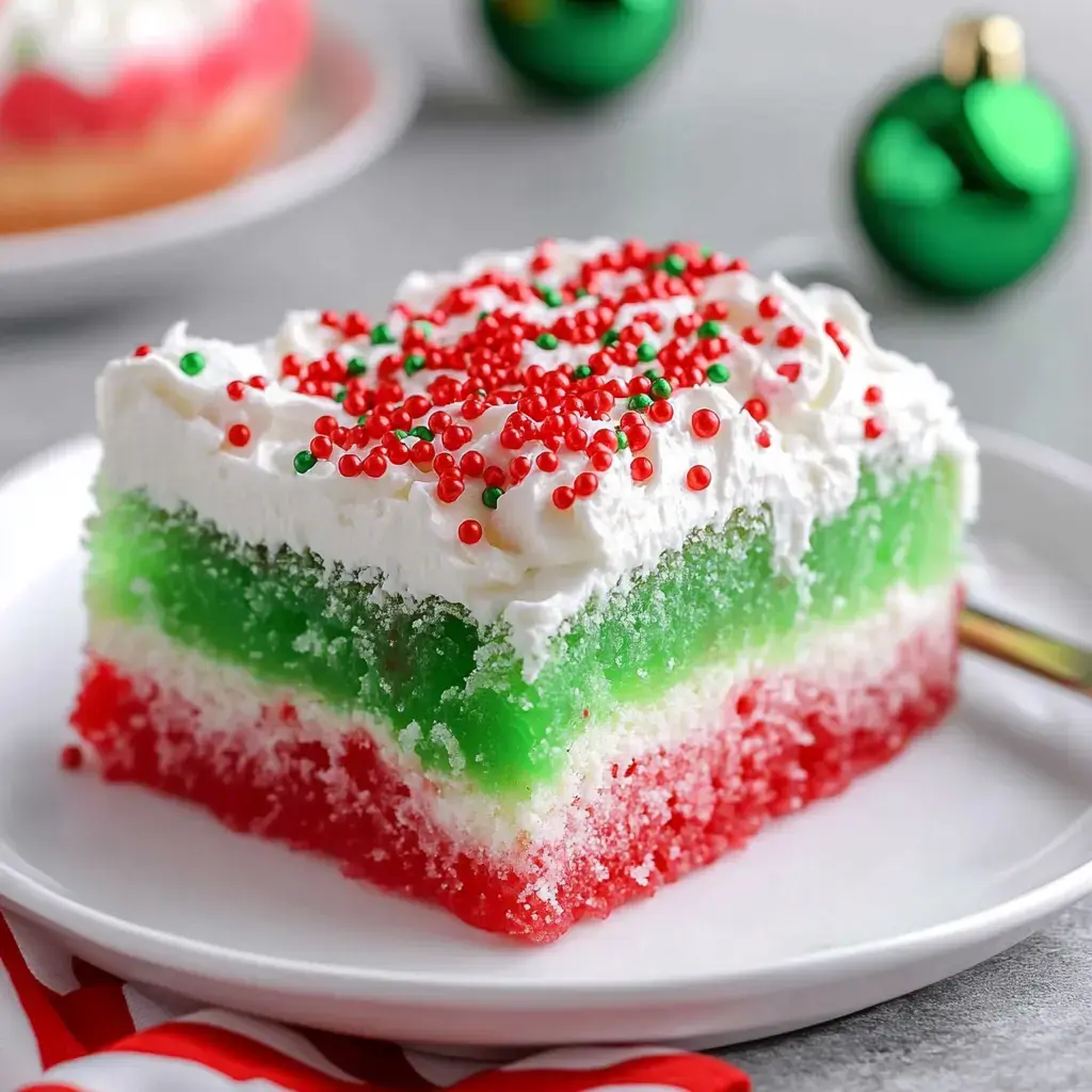 A vibrant red and green layered dessert topped with whipped cream and sprinkles for the holidays.