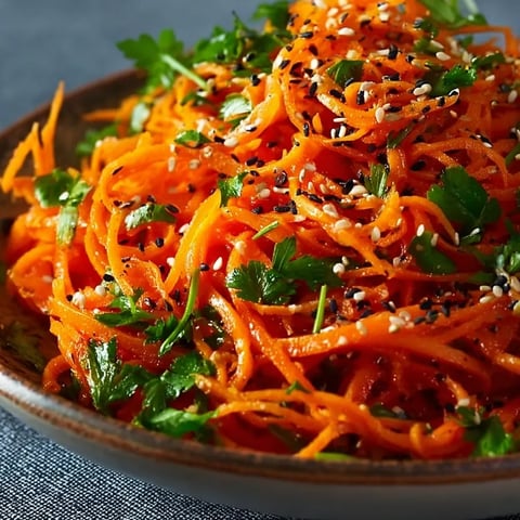 A bowl of shredded carrots with sesame seeds.